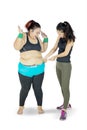 Woman measuring the fat belly of another woman Royalty Free Stock Photo