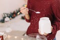 Woman measuring flour with spoon from jar