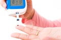 Woman measuring glucose level with blood on a finger by glucometer Royalty Free Stock Photo