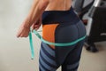 Woman measuring hips with tape in gym, closeup Royalty Free Stock Photo