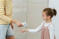 Woman measuring smiling girl& x27;s temperature with a hand sensor