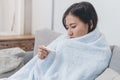 Woman measuring temperature her body on the bed. person got fever lying on the sofa