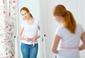 Woman measuring waist in front of mirror Royalty Free Stock Photo