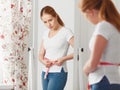 Woman measuring waist in front of mirror Royalty Free Stock Photo