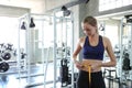 Woman measuring waist in gym. Slim woman measuring her thin waist with a tape measure. smiling people with measure tape in the