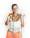 woman measuring waist with tape having choise between apple and donut isolated on white background