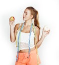 woman measuring waist with tape having choise between apple and donut isolated on white background Royalty Free Stock Photo