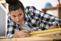 woman measuring wooden plank