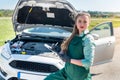 Woman mechanic making some notes about broken car