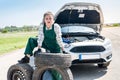 Woman mechanic posing with spare wheel and tyres Royalty Free Stock Photo