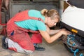 Woman mechanic pumping a tire on a motor bike