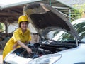 The woman in the mechanic& x27;s work set is using a wrench to open the parts of the engine