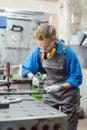 Woman mechanic working in metal workshop