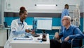 Woman medic showing x ray scan results to patient in wheelchair Royalty Free Stock Photo