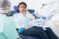 Woman in medical chair complains of toothache to dentist