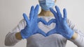 Woman with a medical mask and hands in latex glove shows the symbol of the heart. Doctor for the heart. Love to our pancreas. Royalty Free Stock Photo