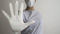 Woman with a medical mask and hands in white latex glove shows the symbol STOP. Stop the disease Royalty Free Stock Photo