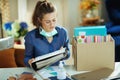 Woman with medical mask organising home office