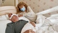 Woman put towel on forehead of man on bed at home Royalty Free Stock Photo