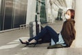 Woman in medical mask sits near luggage in airport. Tortured by the flight, the woman dozes off before the next flight