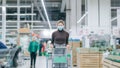 A woman in a medical mask stands in a supermarket with a grocery cart. Protection from coronavirus, buying food in a Royalty Free Stock Photo