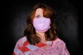 A woman in a medical mask tied with a stop tape on a black background, close-up portrait. Coronavirus and covid-19 flu virus,