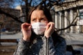 A woman in a medical mask walks alone on the street during the quarantine. Portrait of a female in a protective face mask against