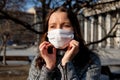 A woman in a medical mask walks alone on the street during the quarantine. Portrait of a female in a protective face mask against
