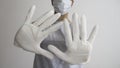 Woman with a medical mask and white latex glove shows the symbol STOP with both hands Royalty Free Stock Photo