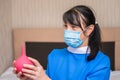 A woman in medical uniform is preparing to do a wash to the patient. Portrait of a nurse in a medical mask with a red enema in