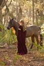 Woman in medieval dress with horse in forest Royalty Free Stock Photo