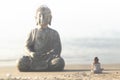 Woman meditates in front of the buddha statue in the middle of nature