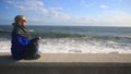 The woman is meditating on the beach during a storm. Equanimity, resistance to stress