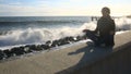 The woman is meditating on the beach during a storm. Equanimity, resistance to stress