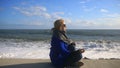 The woman is meditating on the beach during a storm. Equanimity, resistance to stress