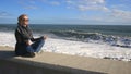 The woman is meditating on the beach during a storm. Equanimity, resistance to stress