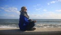 The woman is meditating on the beach during a storm. Equanimity, resistance to stress