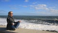 The woman is meditating on the beach during a storm. Equanimity, resistance to stress