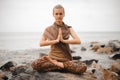 Woman meditating at the beach . yoga retreat. namaste in lotus pose Royalty Free Stock Photo