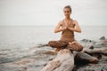 Woman meditating at the beach . yoga retreat. namaste in lotus pose Royalty Free Stock Photo