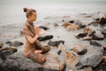 Woman meditating at the beach . yoga retreat. namaste in lotus pose Royalty Free Stock Photo