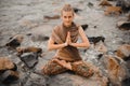 Woman meditating at the beach . yoga retreat. namaste in lotus pose Royalty Free Stock Photo