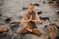 Woman meditating at the beach . yoga retreat. namaste in lotus pose Royalty Free Stock Photo