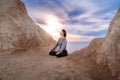 Woman meditating and doing yoga at sunrise