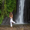 Woman meditating doing yoga between waterfalls Royalty Free Stock Photo