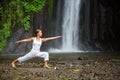 Woman meditating doing yoga between waterfalls