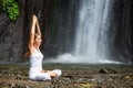 Woman meditating doing yoga between waterfalls Royalty Free Stock Photo