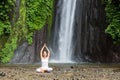 Woman meditating doing yoga between waterfalls Royalty Free Stock Photo