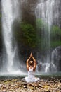 Woman meditating doing yoga between waterfalls Royalty Free Stock Photo