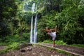 Woman meditating doing yoga between waterfalls Royalty Free Stock Photo